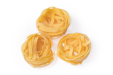 Uncooked noodle coiled into nests on a white background