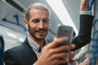 © yurolaitsalbert - attractive man using his smartphone in subway train .