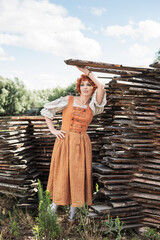 Wall Mural - red haired woman in a Bavarian folk costume on the farm, oktoberfest