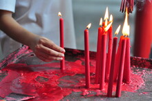 Midsection Of Woman Holding Lit Red Candle