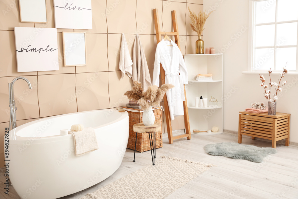 Modern interior of light bathroom with towels and bathrobe