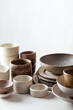 handmade ceramic tableware, empty craft ceramic plates, bowls and cups on light background 