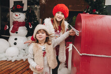 Two Sisters Write A Letter To Santa Claus, Go To The Post Office And Drop The Letter Into The Mailbox.