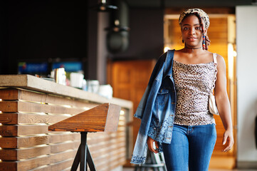 Wall Mural - Lovely african american woman with dreadlocks in leopard outfit at cafe. Beautiful cool fashionable black young girl indoor.