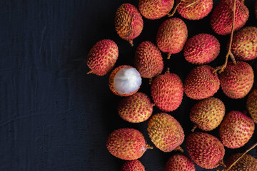 Fresh lychee fruit on a black wooden background