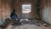 Full Length Of Man Sitting In Abandoned Building