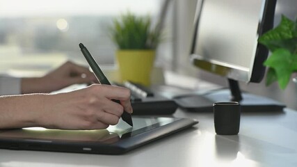 Wall Mural - woman designer draws with stylus on tablet in office at table on sunny day