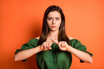 Wall Mural - portrait of upset woman show stop gesture wear dark shirt isolated on orange color background