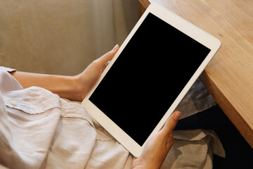 Business woman using mockup tablet on wooden desk