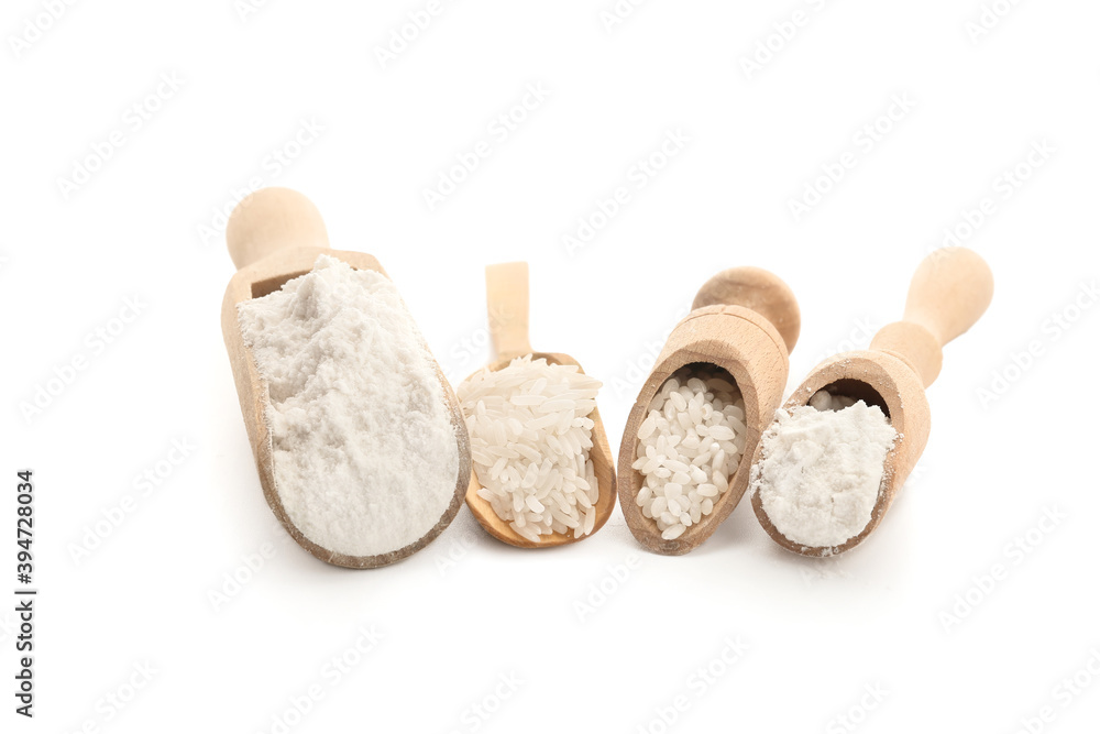 Scoops with rice and flour on white background