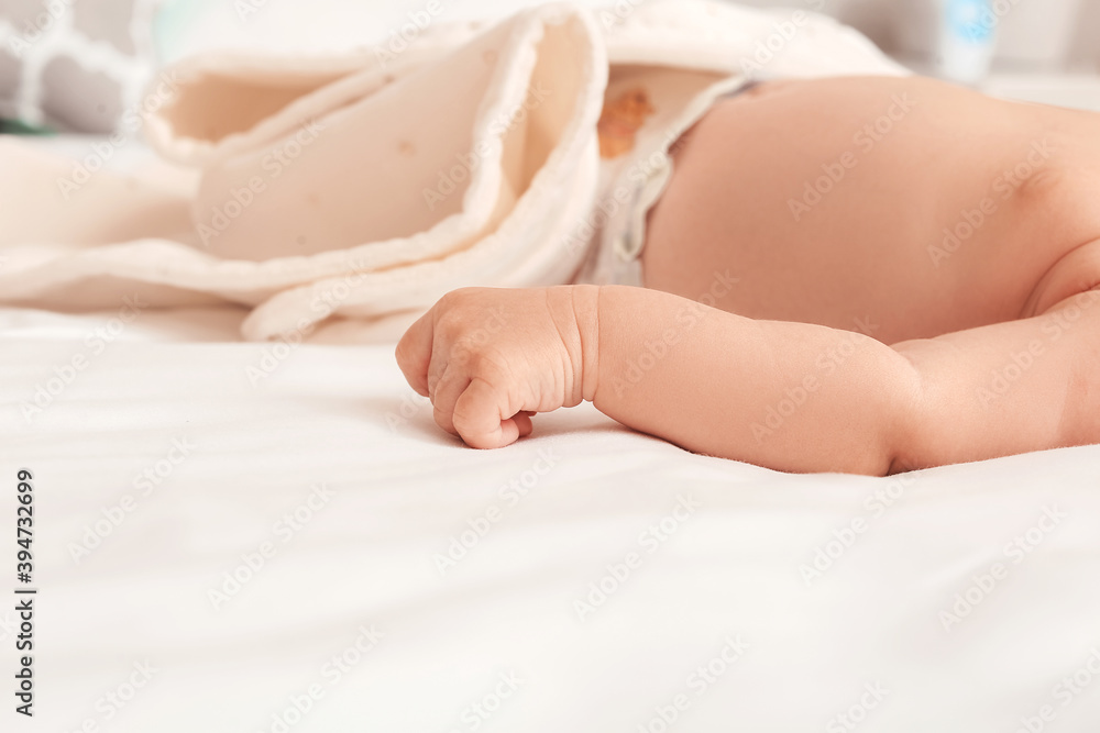 Cute little baby lying on bed at home