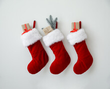 Beautiful Christmas Socks With Gifts Hanging On Light Wall