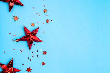 Red Christmas stars and snowflakes on blue background.