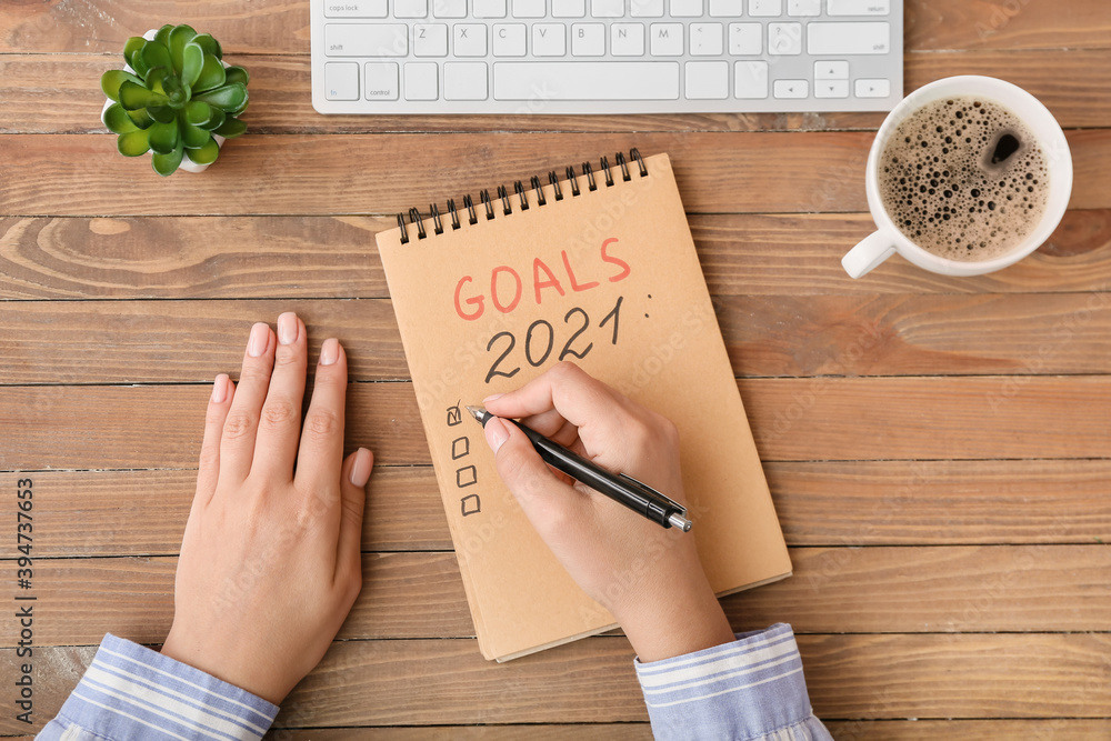 Woman making to-do list on 2021 year at table - obrazy, fototapety, plakaty 
