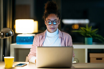 Pretty happy young entrepreneur woman working with laptop sitting in the office.