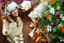 Woman Listening To Music Near Christmas Tree And Gift Boxes