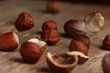 Wall Mural - hazelnuts falling on a structural table made of cracked wood