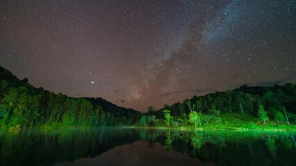 Wall Mural - 4K time lapse of Milky way rise over Pang Oung reservoir in Mae Hong Son, Northern Thailand