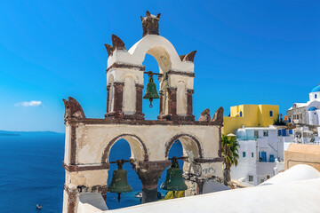 Wall Mural - The bell tower of a traditional Greek church overlooking the caldera in the village of Oia, Santorini in summertime