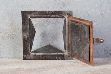 Antique brass chimney flap on gray oncrete background