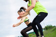 © Georgii - Sportive young couple exercizing jumping or doing squats outdoor, couple workout