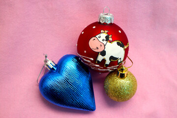 Bright shiny composition with Christmas tree decorations and rain for 2021 with the symbol of the year of the bull, negative space. Looks like a greeting card