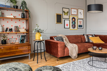 Vintage black poufs in trendy eclectic living room interior with brown couch