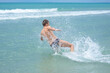 © madhourse - A man accelerating from the shore jumps sideways into the sea water at the resort