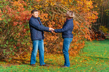 couple walking in autumn city park, happy people together, beautiful nature with colorful leaves