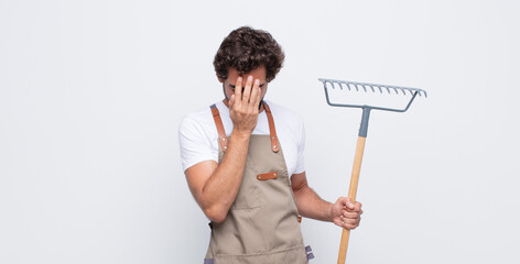 Wall Mural - young man feeling sad, frustrated, nervous and depressed, covering face with both hands, crying