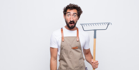 Wall Mural - young man feeling terrified and shocked, with mouth wide open in surprise