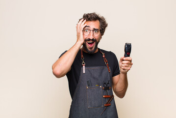 young man raising hands to head, open-mouthed, feeling extremely lucky, surprised, excited and happy