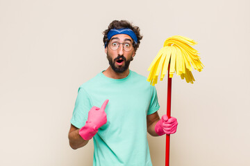 Wall Mural - young man looking shocked and surprised with mouth wide open, pointing to self