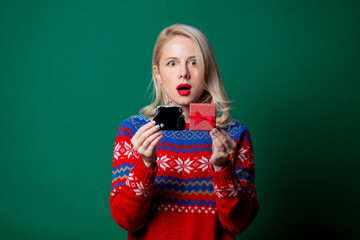 Wall Mural - Beautiful woman in Christmas sweater with gift box and purse