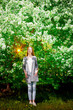© keleny - Outdoor portrait of a beautiful young girl near blossom apple trees with white flowers.
