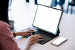 © amnaj - Close up. Woman using digital tablet with blank screen on black table and smartphone in office.
