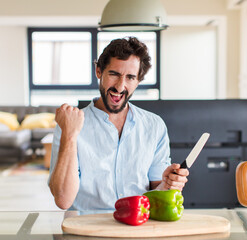 Wall Mural - bearded man shouting aggressively with an angry expression or with fists clenched celebrating success