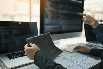 Two software developers are analyzing together about the code written into the program on the computer.