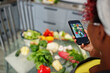 © AS Photo Family - African american woman filming her blog broadcast about healthy food at home kitchen and making picture on phone.
