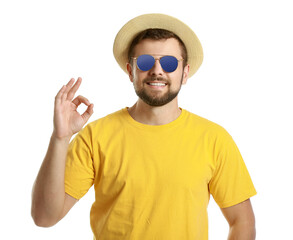 Wall Mural - Handsome man with stylish sunglasses showing OK gesture on white background