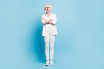 Wall Mural - Full length body size photo of senior woman with folded hands wearing white clothes isolated on bright blue color background