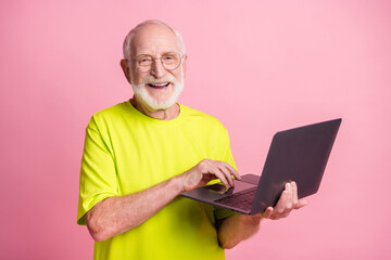 Wall Mural - Portrait of funky pensioner typing laptop wear spectacles lime color t-shirt isolated on pastel pink color background