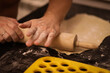 © polukarovaanna - cook rolls out the dough, men's hands work with the dough, cooking dough for dumplings, cook's hands in flour