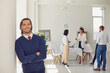 © Studio Romantic - Happy businessman or company worker standing in office looking at camera and smiling