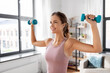 © Syda Productions - fitness, sport and healthy lifestyle concept - smiling young woman with dumbbells exercising at home