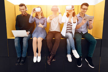 People sit together and look in virtual glasses.