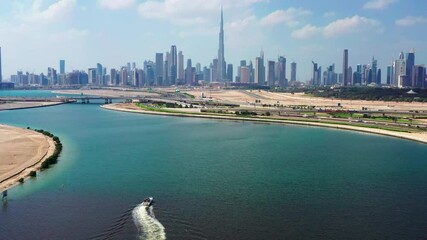 Wall Mural - Panoramic aerial view of Dubai city skyline on cloudy day moving over man made lake