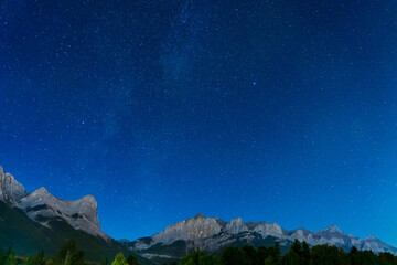 Wall Mural - Starry sky with Rocky Mountains Mount Rundle in summer night.