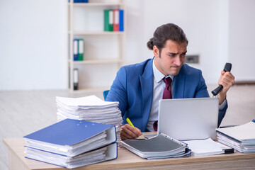 Young male employee unhappy with excessive work in the office