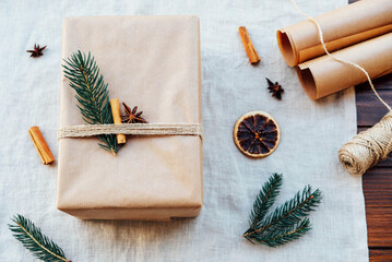  Wrapping gifts with natual decorations such as fir branch, cinnamon sticks, dry orange slice. Zero waste Christmas concept. Plastic free holidays. Sustainable lifestyle.